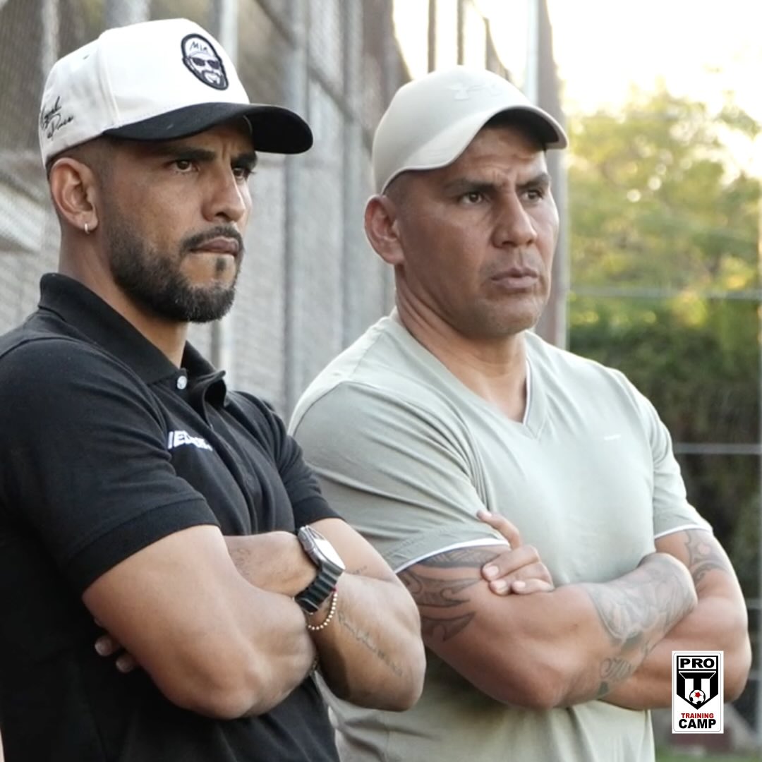Carlos Salcido observando el entrenamiento a un costado de la cancha junto a un miembro del cuerpo técnico.